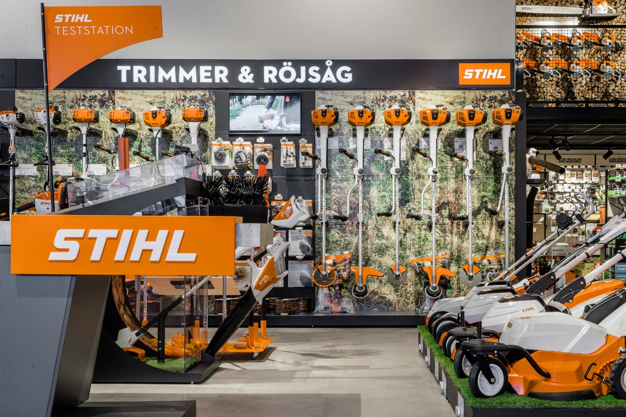 A woman cuts the tall grass around a bed border with the STIHL FSA 60 R brush cutter.
